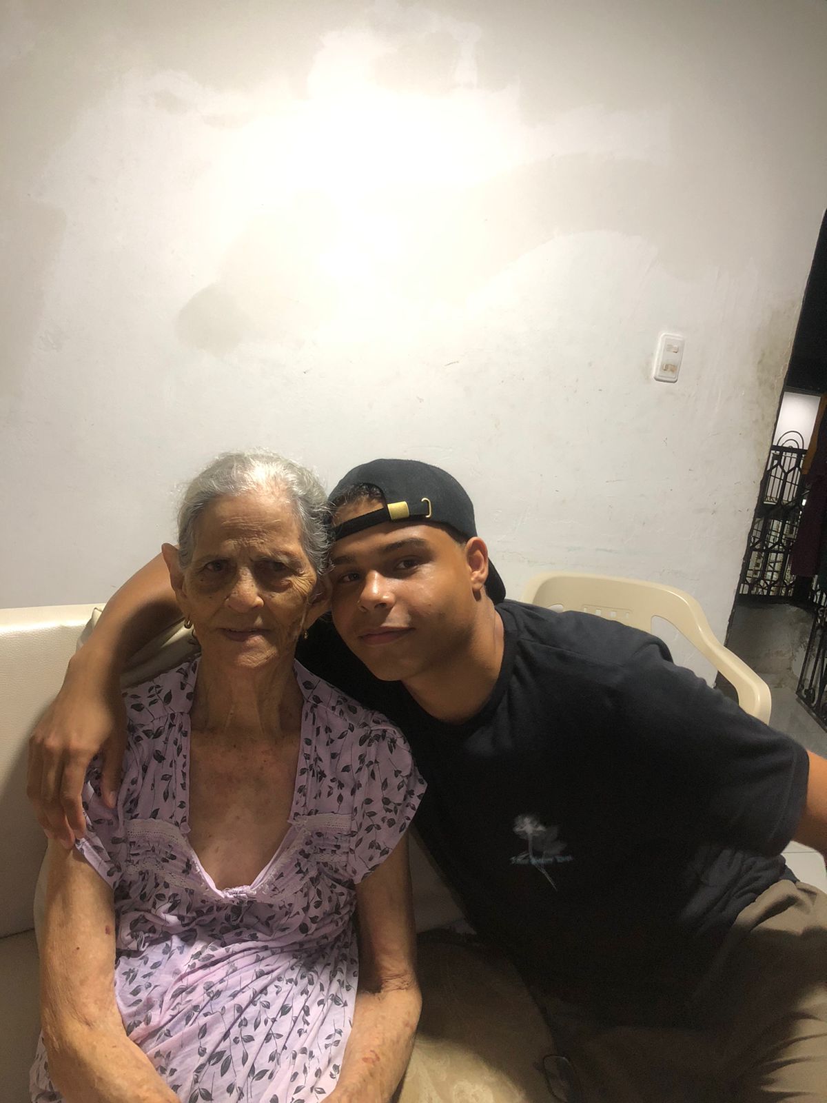 Santiago Villalobos sitting with his arm around an older woman.