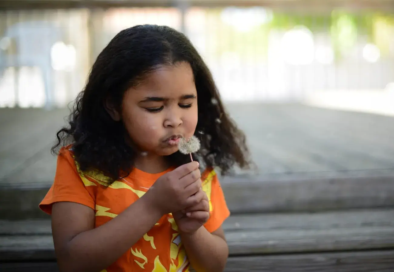 Photo of Duaa Babekr holding a dandelion 